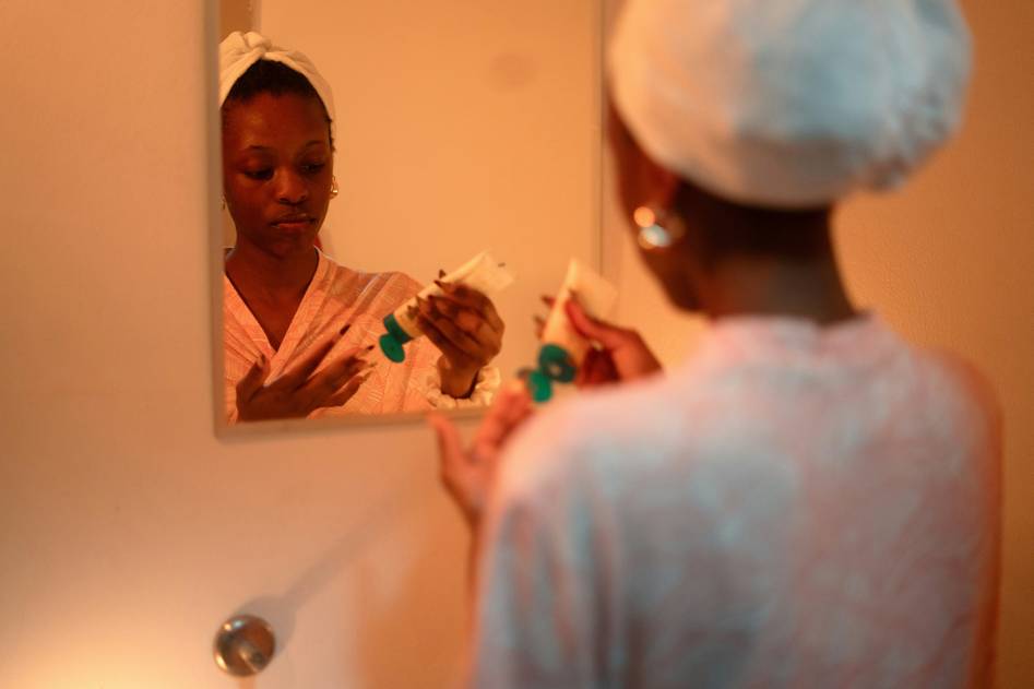 Woman applying serum for glowing skin routine at sunrise